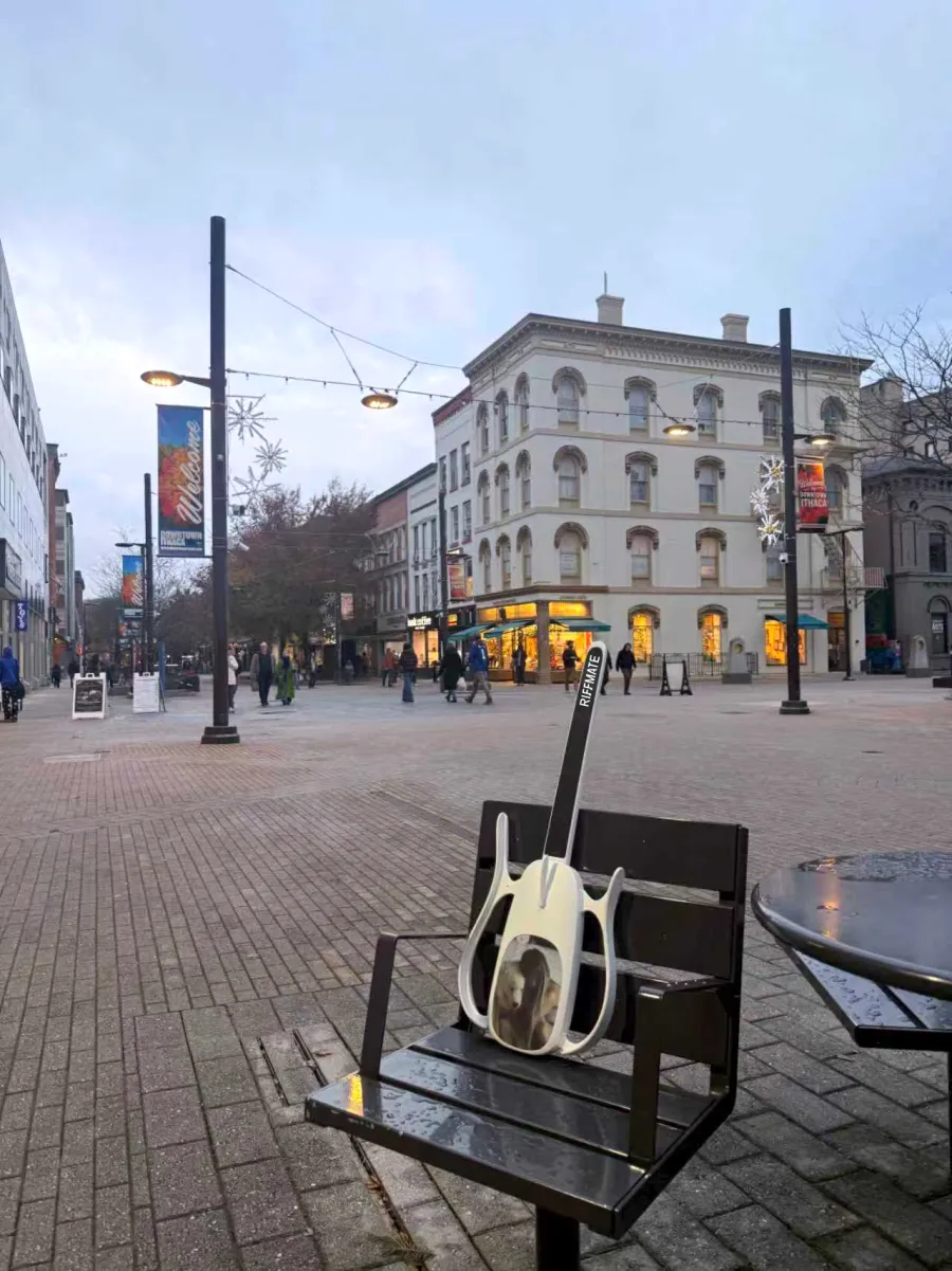 RIFFMATE smart guitar resting on a bench at Ithaca Commons, New York
